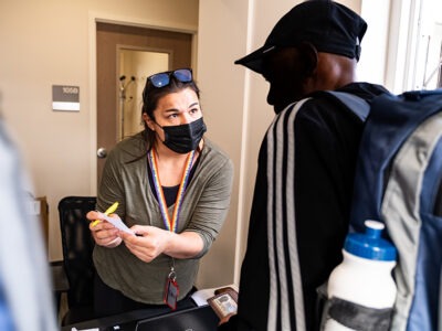 Lauren Lapinski, Coordinated Entry Specialist at the VA Eastern Colorado Health Care System checks in participants at the 2023 Annual Homelss Veterans Stand Down event at the VA Community Resource and Referral Center in Denver, Colorado.